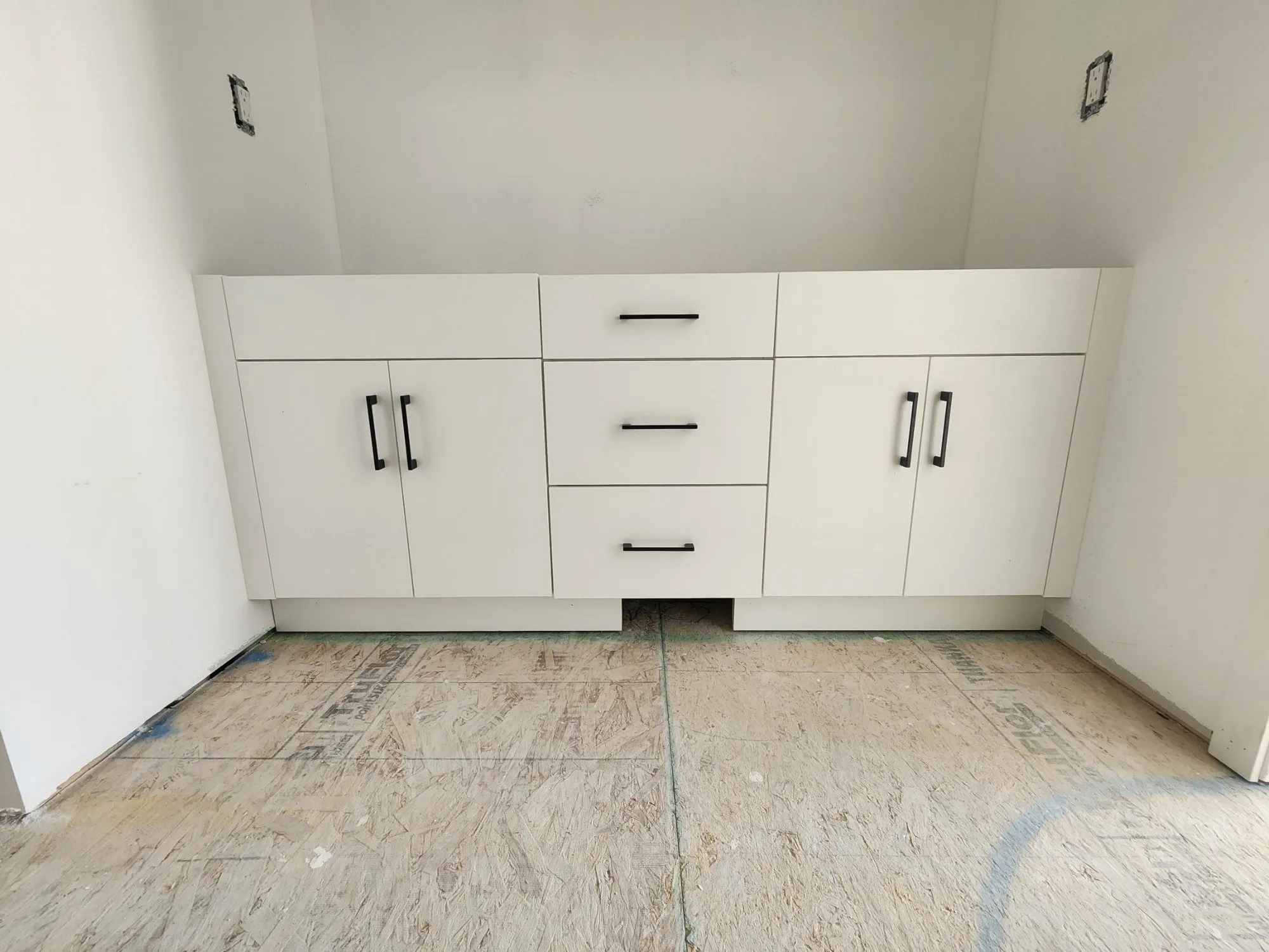 Double vanity with a centre drawer bank and black bar pulls
